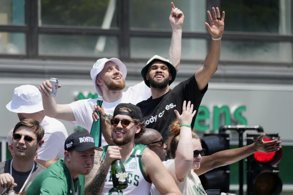 Boston Celtics' Derrick White, right, celebrates the team's NBA basketball championship during a duck boat parade Friday, June 21, 2024, in Boston. (AP Photo/Michael Dwyer)