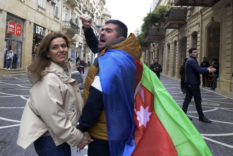Azerbaijanis with the national flag celebrate after the country's President claimed Azerbaijani forces have taken Shushi, a key city in the Nagorno-Karabakh region that has been under the control of ethnic Armenians for decades in Baku, Azerbaijan, Sunday, Nov. 8, 2020. (AP Photo)