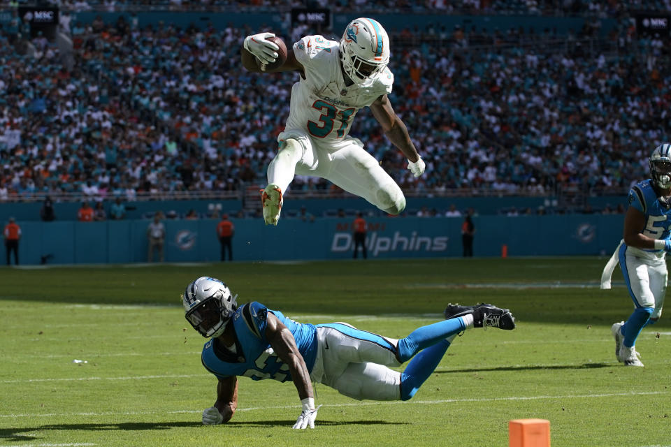 Miami Dolphins running back Raheem Mostert (31) jumps over Carolina Panthers cornerback CJ Henderson (23) during the second half of an NFL football game, Sunday, Oct. 15, 2023, in Miami Gardens, Fla. (AP Photo/Lynne Sladky)