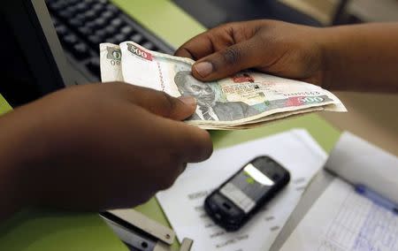 A customer conducts a mobile money transfer, known as M-Pesa, inside the Safaricom mobile phone care centre in the central business district of Kenya's capital Nairobi July 15, 2013. REUTERS/Thomas Mukoya