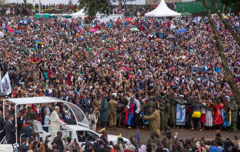 Pope Francis waves to the crowd at the University of Nairobi as he arrives to deliver an open-air mass on November 26, 2015