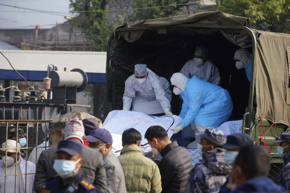 Medical personnel load the body of a victim onto a truck to be transported to Kathmandu, in Pokhara, Nepal, Tuesday, Jan 17, 2023. Nepalese authorities on Tuesday began returning to families the bodies of victims of a flight that crashed Sunday, and said they were sending the aircraft's data recorder to France for analysis as they try to determine what caused the country's deadliest plane accident in 30 years. (AP Photo/Yunish Gurung)