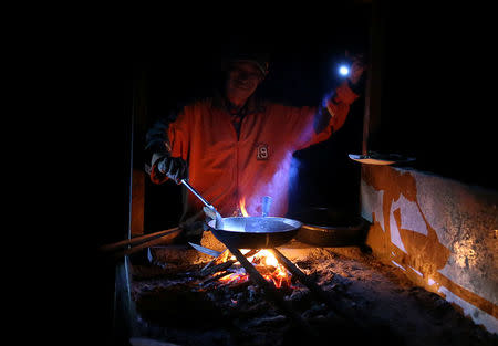 An evacuee uses a flashlight while cooking their meals at an evacuation site in the municipality of Pantar, Lanao Del Sur. REUTERS/Romeo Ranoco