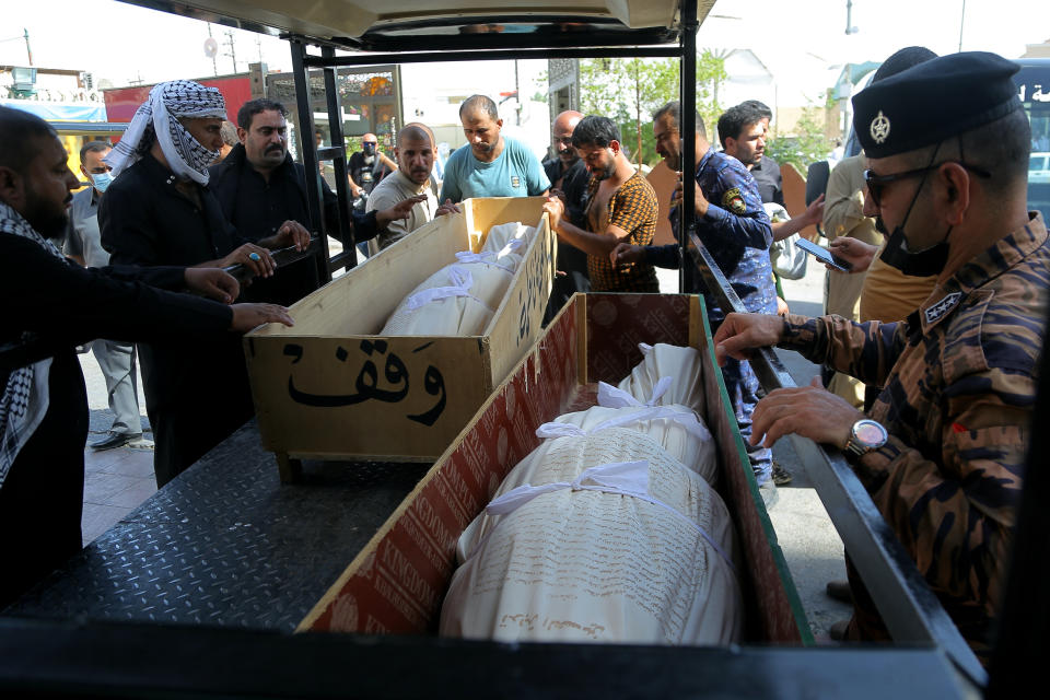 Mourners prepare to bury hospital fire victims in Najaf, Iraq, Tuesday, July 13, 2021. A catastrophic blaze erupted at a coronavirus hospital ward in southern Iraq of Nasiriyah on Monday. It was the second time a large fire killed coronavirus patients in an Iraqi hospital this year. (AP Photo/Anmar Khalil)