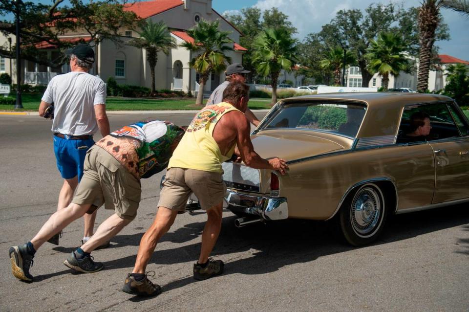 Volunteers help push a broken down vehicle at Cruisin’ Central at Centennial Plaza during Cruisin’ the Coast on Tuesday, Oct. 3, 2023.