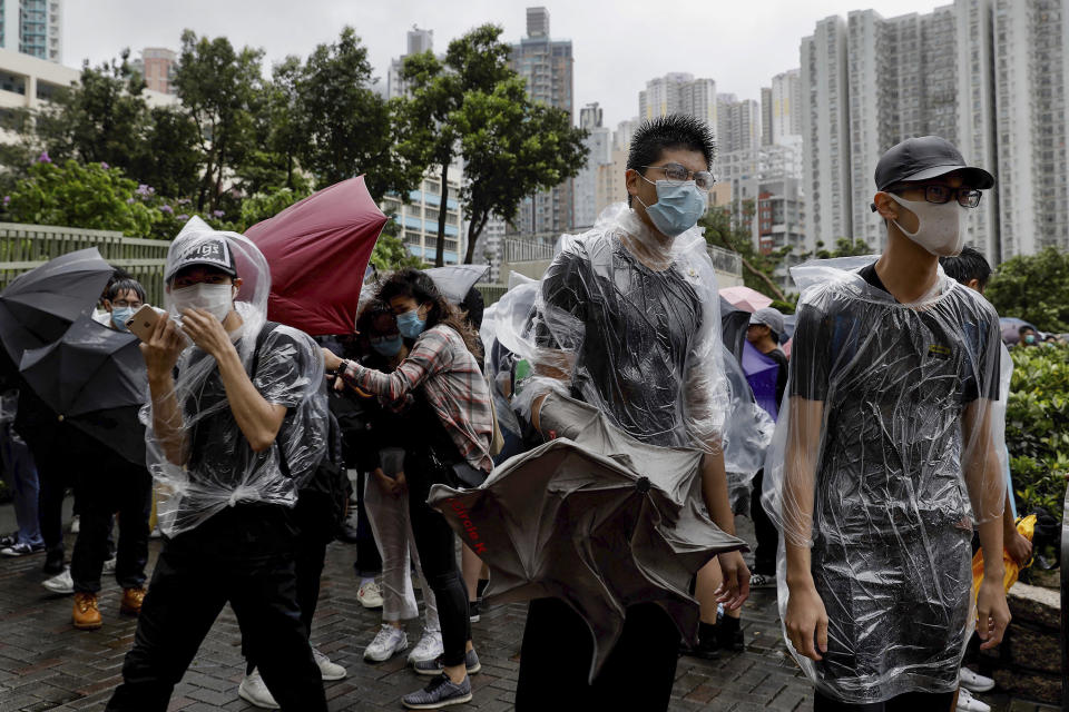 Protesters brace themselves against the strong wind and heavy rain as they gather outside the Eastern Court in Hong Kong, Wednesday, July 31, 2019. Charges were read Wednesday against more than 20 Hong Kong protesters who have been accused of rioting - the most serious charge brought since mass demonstrations began in the city last month. (AP Photo/Vincent Yu)