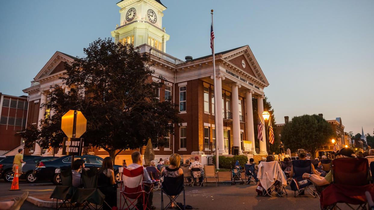 Jonesborough, Tennessee, USA - July 11, 2014: People gather with their outdoor chairs in front of the courthouse on Main Street in historic Jonesborough.