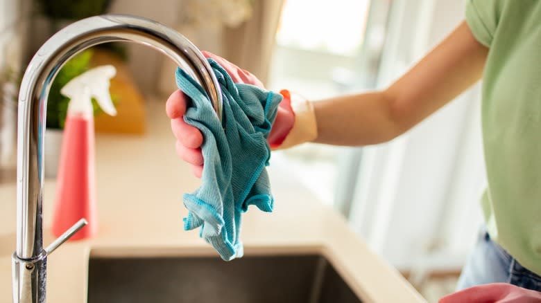 Person polishing kitchen faucet