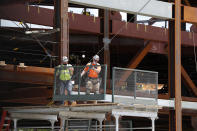 Workers resume their jobs on the New York Islanders' hockey team's new arena, located adjacent to Belmont race track, as some parts of Long Island reopened during the current coronavirus outbreak, Wednesday, May 27, 2020, in Elmont, New York. Long Island became the latest region of New York to begin easing restrictions put in place to curb the spread of the coronavirus as it entered the first phase of the state's four-step reopening process. (AP Photo/Kathy Willens)