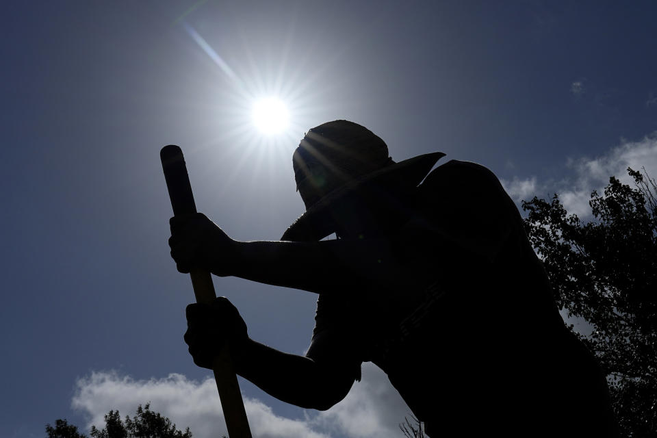 Carlos Rodriguez digs fence post holes in Houston