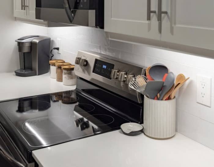 A kitchen counter lit by lighting installed under the cabinets