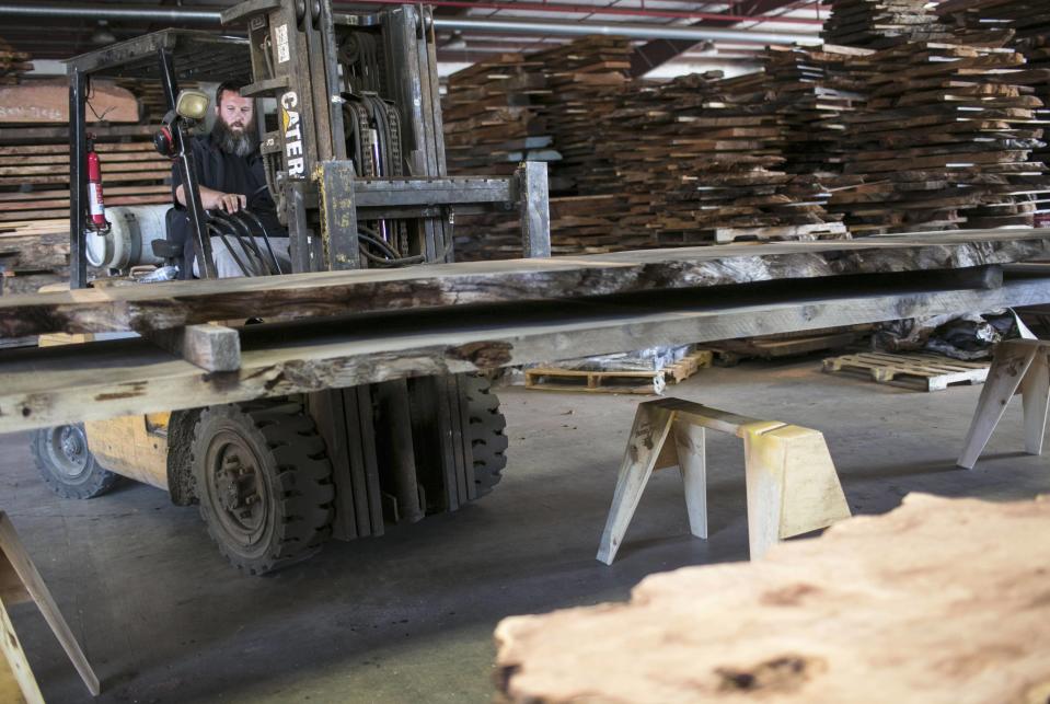 Landon Buck, owner of Redwood Burl Inc., works at the warehouse in Arcata, California