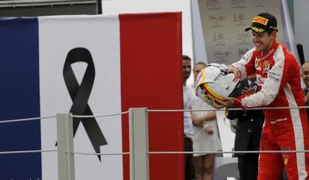 Ferrari's Formula One driver Sebastian Vettel of Germany celebrates after taking third place in the Brazilian F1 Grand Prix in Sao Paulo, Brazil, November 15, 2015. REUTERS/Nacho Doce