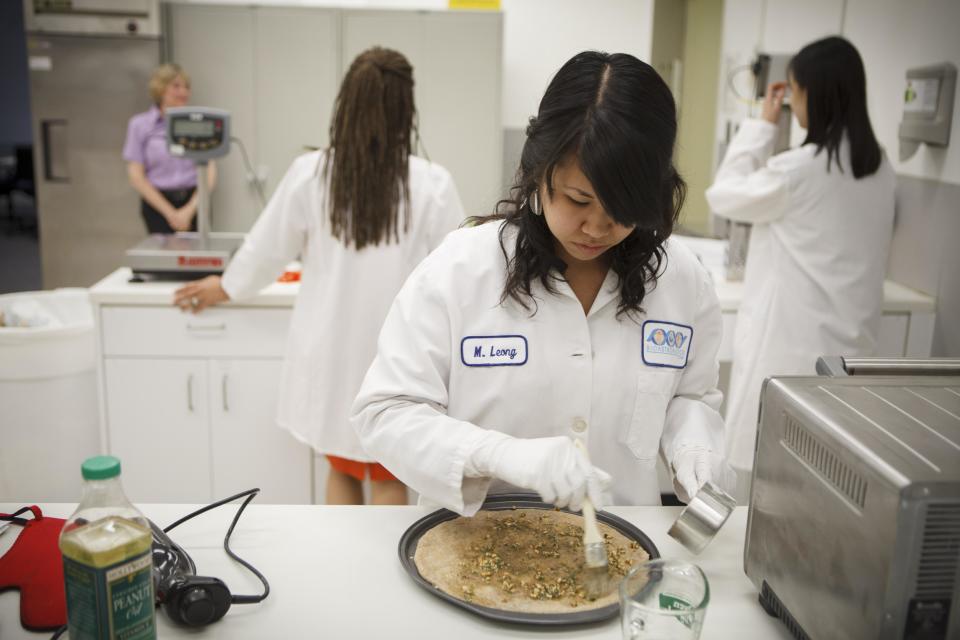 Lockheed Martin associate research scientist Monica Leong, prepares and bakes a vegan pizza from a recipe developed for a mission to Mars at NASA's Advanced Food Technology Project at Johnson Space Center in Houston Tuesday, July 3, 2012. NASA is currently planning a mission to Mars, which has gravity, so more options for food preparation, like chopping vegetables, are available as opposed to the dehydrated fare of current space missons. (AP Photo/Michael Stravato)