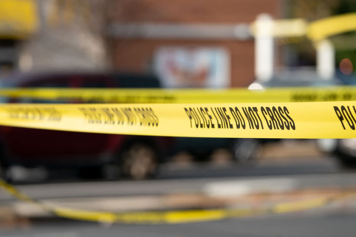 Yellow police tape blocking off a crime scene (Stefani Reynolds/AFP via Getty Images)