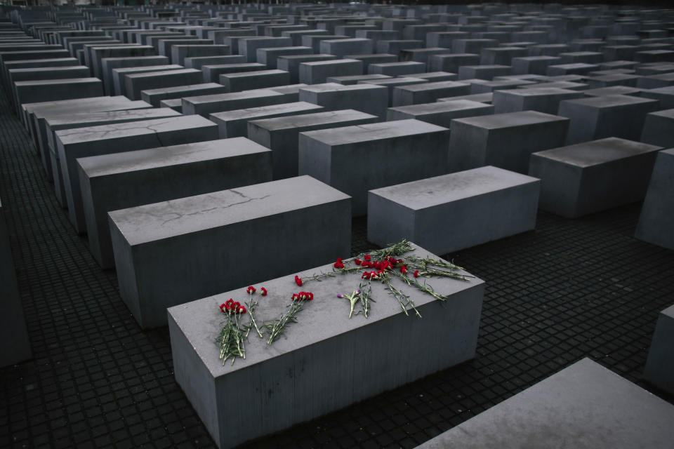 FILE - Flowers lie on a concrete slab of the Holocaust Memorial to mark the International Holocaust Remembrance Day and commemorating the 70th anniversary of the liberation of the Nazi Auschwitz death camp in Berlin, Jan. 27, 2015. Almost 80 years after the Holocaust, about 245,000 Jewish survivors are still living across more than 90 countries, according to the report by the New York-based Conference on Jewish Material Claims Against Germany. (AP Photo/Markus Schreiber, File)