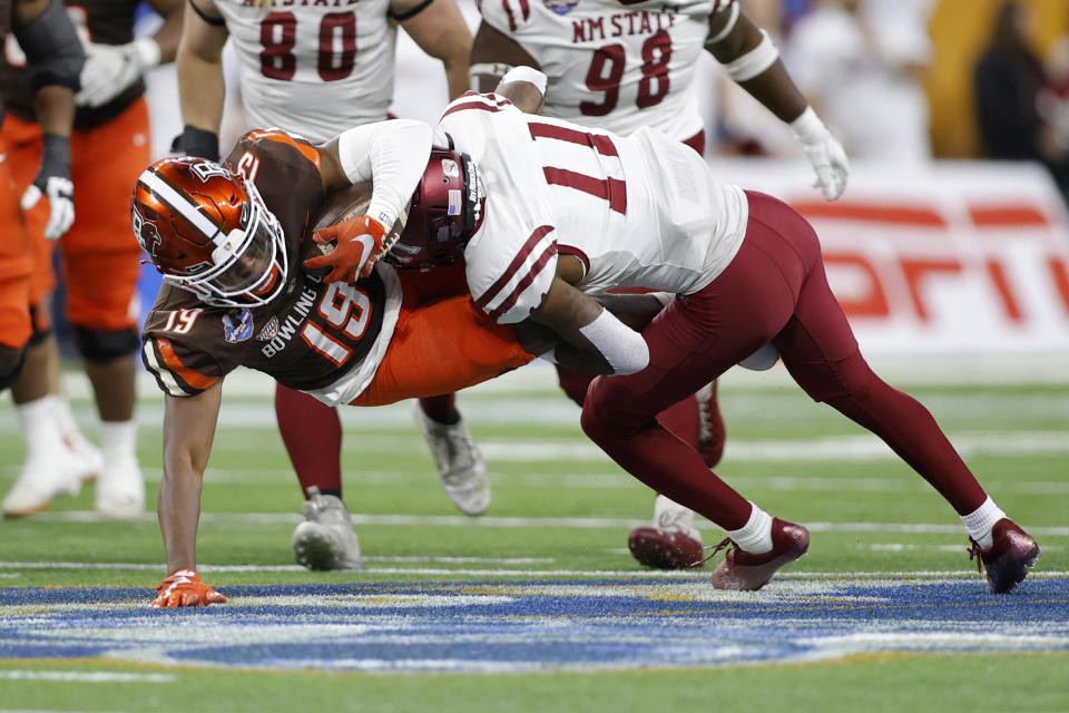 Bowling Green running back Ta'ron Keith, left, is tackled by New Mexico State defensive back Dylan Early (11) during the first half of the Quick Lane Bowl NCAA college football game, Monday, Dec. 26, 2022, in Detroit. (AP Photo/Al Goldis)
