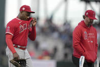 Los Angeles Angels left fielder Justin Upton, left, wipes his face as he walks off the field with a trainer after colliding with teammate Juan Lagares during the fourth inning against the San Francisco Giants in a baseball game Tuesday, June 1, 2021, in San Francisco. (AP Photo/Tony Avelar)