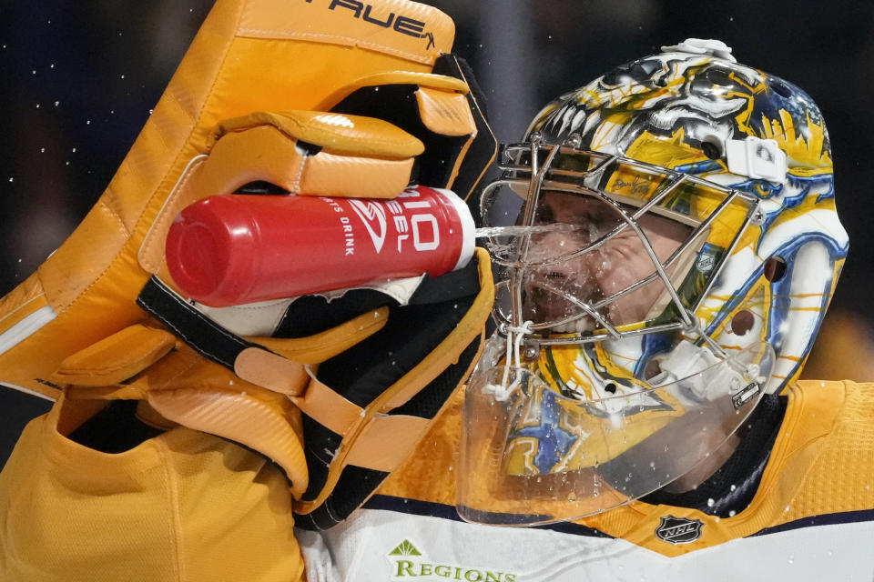 Nashville Predators goaltender Juuse Saros splashes water in his face during the first period of an NHL hockey game against the Arizona Coyotes Saturday, Jan. 20, 2024, in Tempe, Ariz. (AP Photo/Ross D. Franklin)