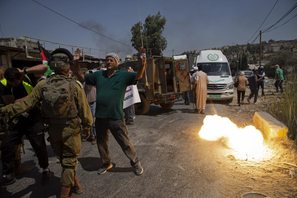 A sound grenade is fired by Israeli forces during a protest against the creation of a new road for Israeli settlers, near the Palestinian village of Beita, north of the West Bank city of Nablus, Wednesday, Aug. 25, 2021. (AP Photo/Majdi Mohammed)