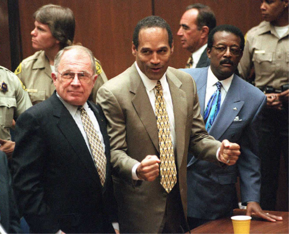 Murder defendant OJ Simpson (C) celebrates the not guilty verdict with his attorneys F Lee Bailey (L) and Johnnie Cochran Jr (R) (Myung J Chun /AFP via Getty Images)