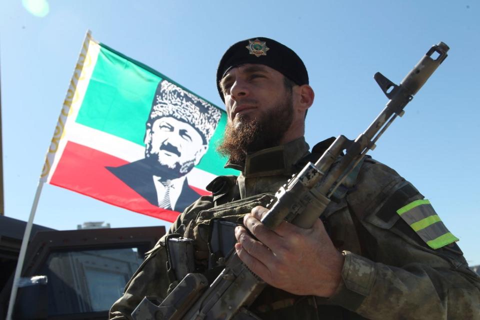 Un militar delante de una bandera de Akhmad Kadyrov y escuchando a Ramzan Kadyrov hablar a las tropas en Grozny, 29 de marzo de 2022 (AP)