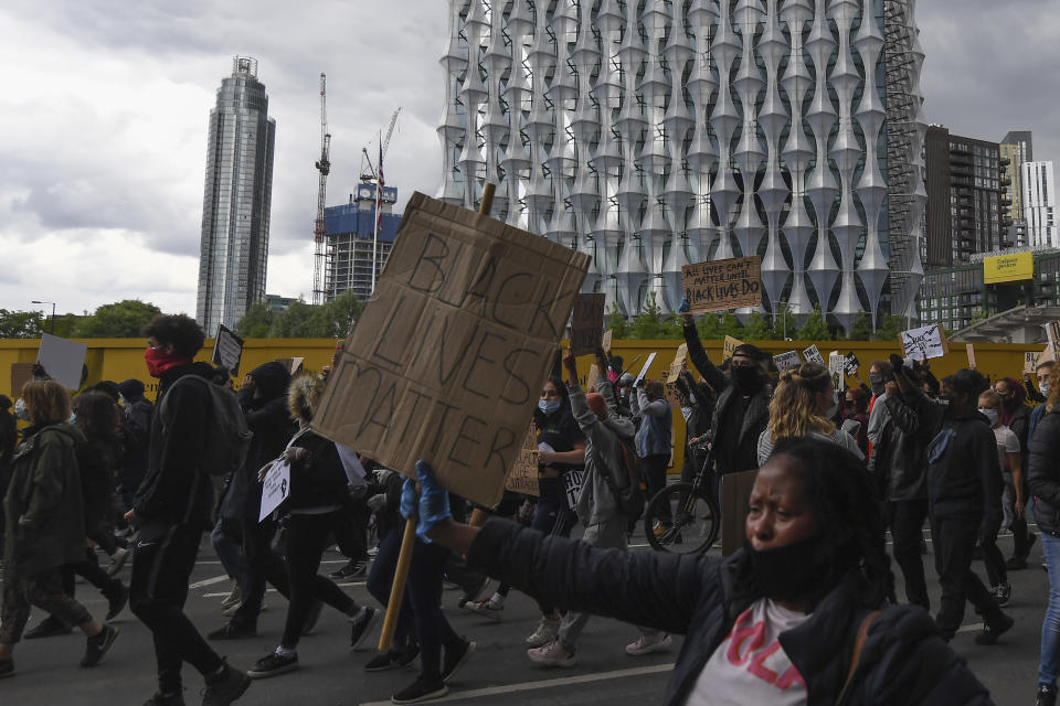 Protesters carry placards in front of the US embassy, during the Black Lives Matter protest rally in London, Sunday, June 7, 2020, in response to the recent killing of George Floyd by police officers in Minneapolis, USA, that has led to protests in many countries and across the US. (AP Photo/Alberto Pezzali)