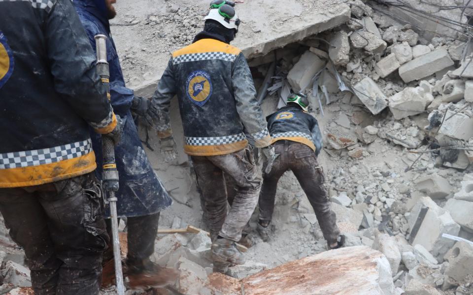 White Helmets rescuers search for survivors under the rubble, following an earthquake, in Al Atareb, Syria - White Helmets