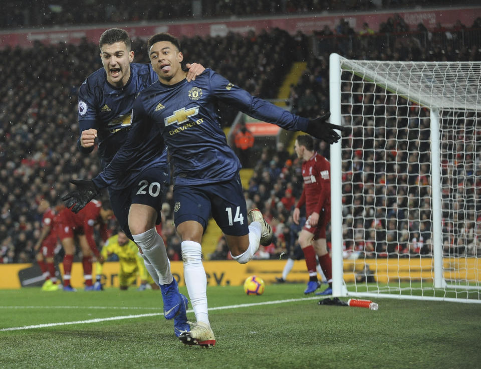 Manchester United's Jesse Lingard, right, celebrates with his teammate Diogo Dalot after scoring his side's opening goal during the English Premier League soccer match between Liverpool and Manchester United at Anfield in Liverpool, England, Sunday, Dec. 16, 2018. (AP Photo/Rui Vieira)