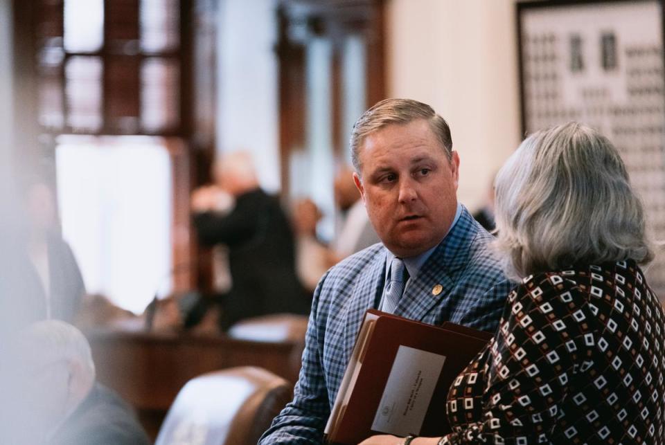 State Rep. Justin Holland, R-Rockwall, speaks with a colleague on the House floor in Austin on April 18, 2023.