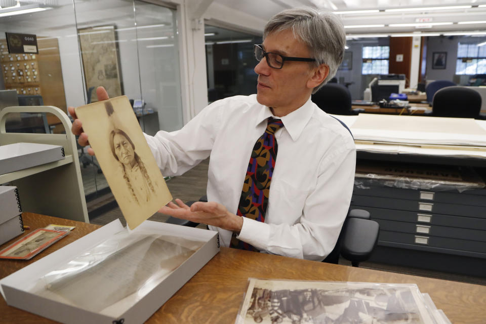 In this Thursday, Nov. 14, 2019 photo, University of Michigan William Clements Library Curator of Graphics, Clayton Lewis, shows a photograph of Sitting Bull from the photographic collection acquired by the library in 2016 from Richard Pohrt Jr. in Ann Arbor, Mich. The trove, representing some 80 indigenous groups, includes photos from government-sponsored expeditions, stereographic and cartes de visites. (AP Photo/Carlos Osorio)