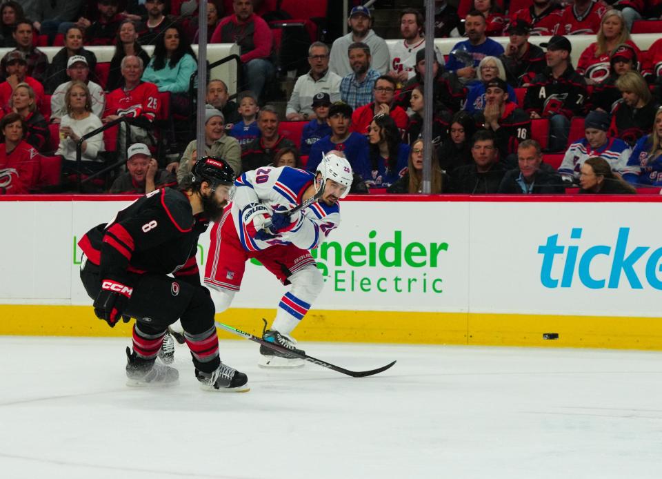 Mar 12, 2024; Raleigh, North Carolina, USA; New York Rangers left wing Chris Kreider (20) gets the shot past Carolina Hurricanes defenseman Brent Burns (8) during the second period at PNC Arena.