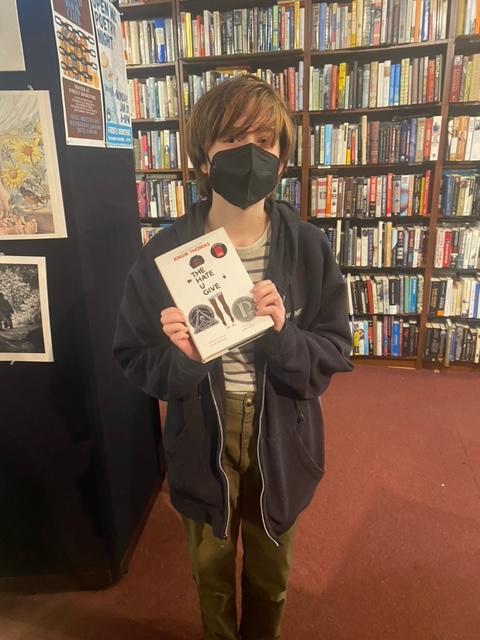 A Banned Book Club student poses with their latest read, 