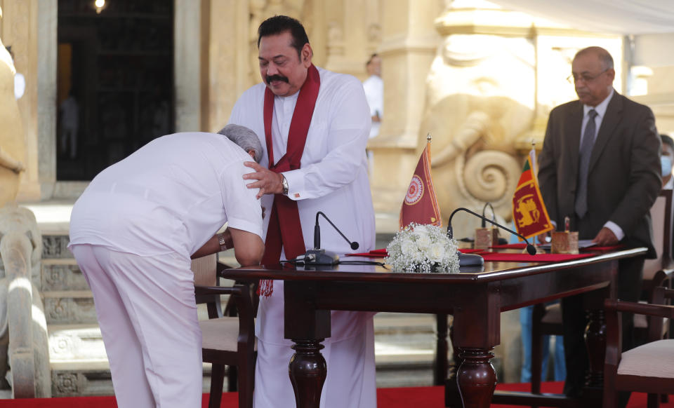 Sri Lanka’s former President Mahinda Rajapaksa, center, blesses his younger brother, President Gotabaya Rajapaksa, who pays respect after being sworn in as the prime minister at Kelaniya Royal Buddhist temple in Colombo, Sri Lanka, Sunday, Aug. 9, 2020. (AP Photo/Eranga Jayawardena)