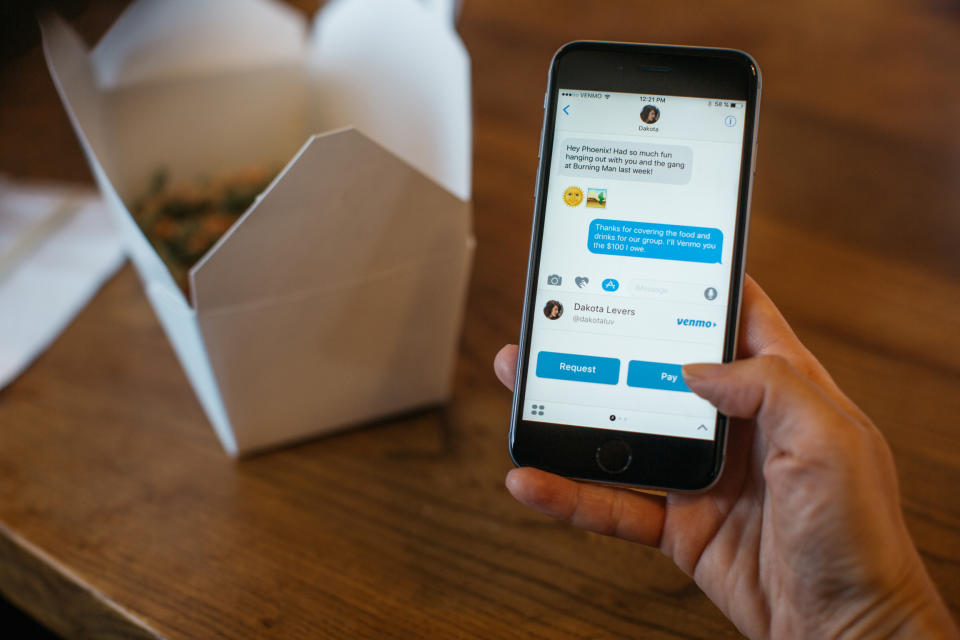 A person using the Venmo app, with a Chinese takeout food container on the table in the background