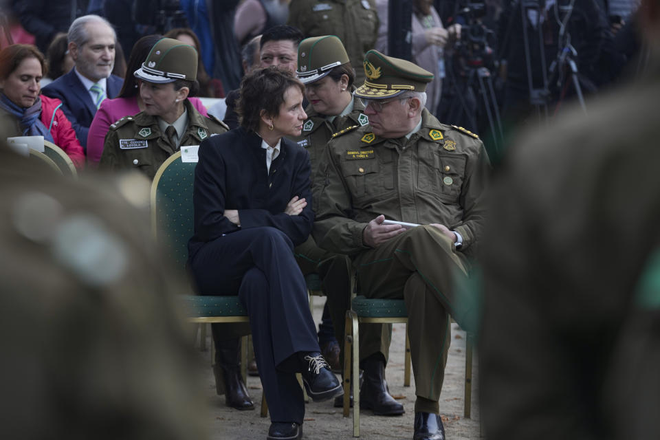 La ministra del Interior, Carolina Tohá, centro izquierda, habla con el jefe general de Carabineros de Chile, Ricardo Yáñez, durante una ceremonia de inicio del programa "Calles sin Violencia" patrocinado por el gobierno en Santiago, Chile, el lunes 24 de abril de 2023. (AP Foto/Esteban Felix)