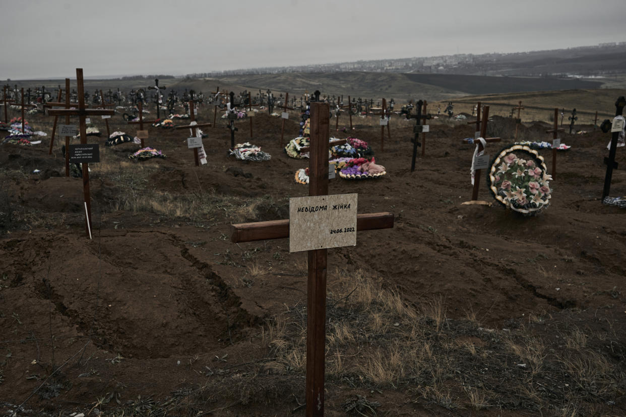 A cross on the new tomb with the writing "Unknown woman" in a cemetery in Bakhmut, the site of the heaviest battles with the Russian invaders, in the Donetsk region, Ukraine, Sunday, Dec. 18, 2022. (AP Photo/LIBKOS)