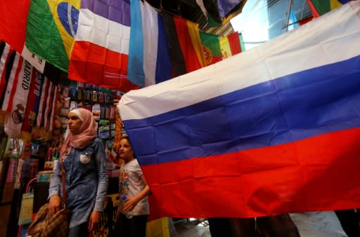 A picture taken on June 7, 2018 shows flags of countries participating in the 2018 FIFA World Cup on display among other flags outside a stall in the old city of the Syrian capital Damascus