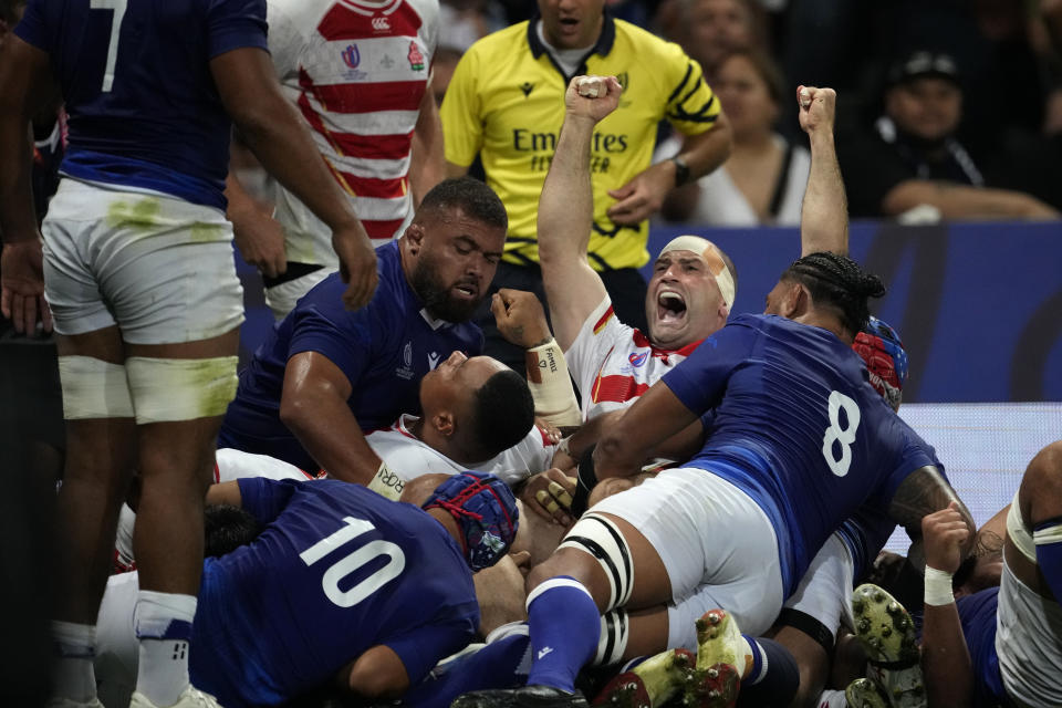 Japan's Craig Millar, centre, celebrates after his captain Kazuki Himeno scored a try during the Rugby World Cup Pool D match between Japan and Samoa, at the Stadium de Toulouse in Toulouse, France, Thursday, Sept. 28, 2023. (AP Photo/Christophe Ena)