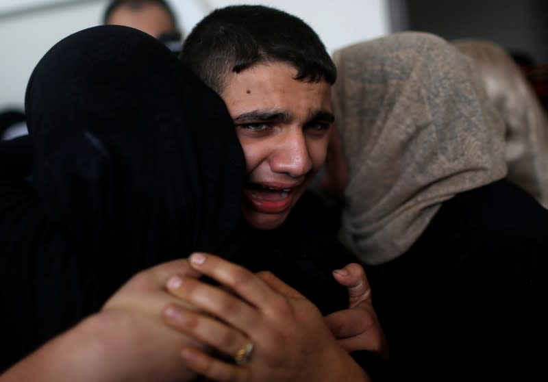 Son of Palestinian Islamic Jihad field commander Baha Abu Al-Atta mourns during his father's funeral in Gaza City