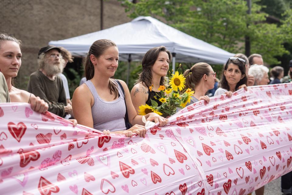 Participants stretch out a banner of 34,000 hearts at the Protect Pisgah Party and Rally outside of the National Forests in North Carolina's Forest Supervisor's office in Asheville on August 1, 2022.