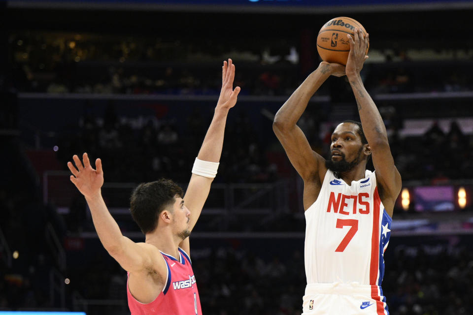 Brooklyn Nets forward Kevin Durant (7) looks to shoot against Washington Wizards forward Deni Avdija (9) during the second half of an NBA basketball game, Monday, Dec. 12, 2022, in Washington. (AP Photo/Nick Wass)