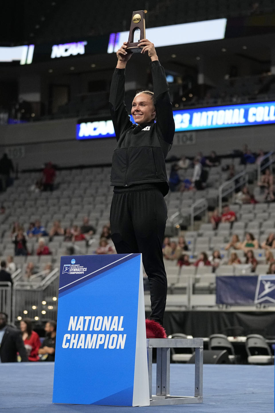 Utah's Maile O'Keefe holds up a trophy after winning the all around title in the NCAA women's gymnastics championships, Thursday, April 13, 2023, in Fort Worth, Texas. (AP Photo/Tony Gutierrez)