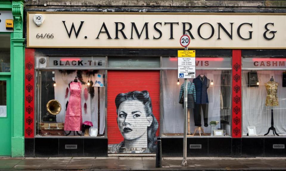 Armstrongs vintage clothing store with the shutter down revealing a retro protrait of a young woman.M4C074 Armstrongs vintage clothing store with the shutter down revealing a retro protrait of a young woman.