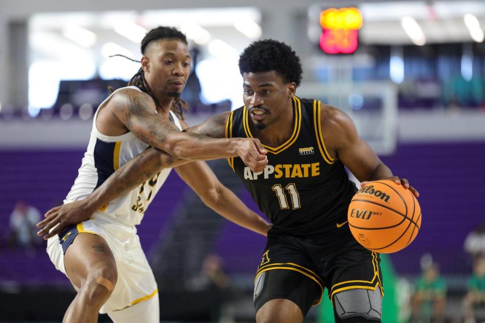 Nov 22, 2023; Fort Myers, FL, USA; Appalachian State Mountaineers forward Donovan Gregory (11) moves the ball past Murray State Racers guard Brian Moore Jr. (14) in the second half during the Fort Myers Tip-Off at Suncoast Credit Union Arena. Mandatory Credit: Nathan Ray Seebeck-USA TODAY Sports