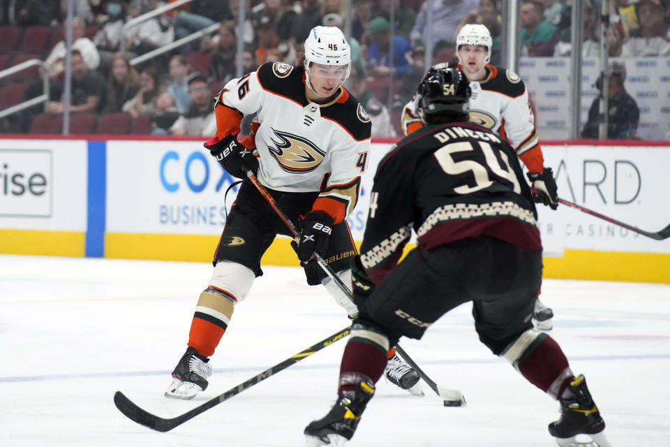 Anaheim Ducks center Trevor Zegras (46) carries the puck in front of Arizona Coyotes defenseman Cam Dineen (54) during the first period of an NHL hockey game Friday, April 1, 2022, in Glendale, Ariz. (AP Photo/Rick Scuteri)