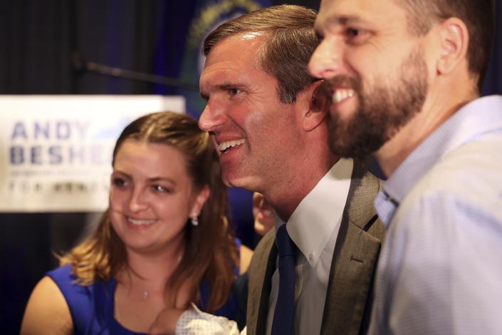Kentucky Gov. Andy Beshear, center, poses with supporters after winning the Democrat primary election at the Kentucky Historical Society in Frankfort, Ky., Tuesday, May 16, 2023. (AP Photo/James Crisp)