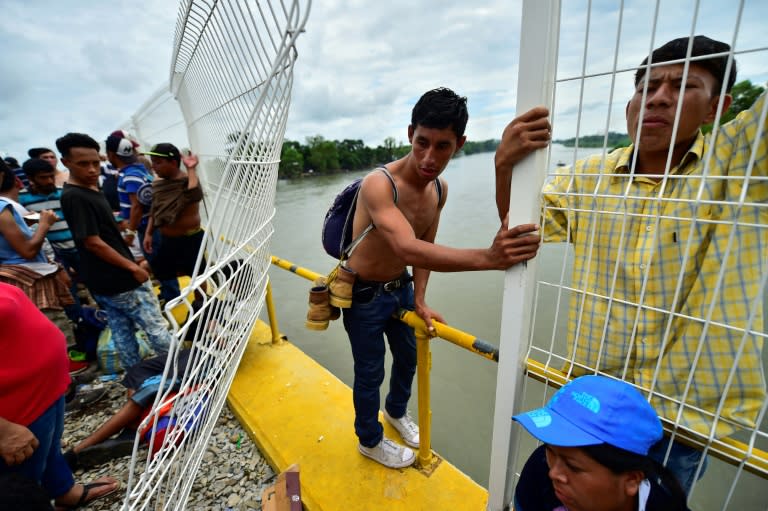 Honduran migrants heading in a caravan to the US prepare to jump into the Suchiate River from the Guatemala-Mexico international border bridge in Ciudad Hidalgo, Mexico, on October 20, 2018