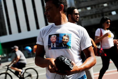 FILE PHOTO: A supporter wears a T-shirt with the images of presidential candidate Jair Bolsonaro and U.S. President Donald Trump at Paulista Avenue after Bolsonaro was stabbed in Juiz de Fora, in Sao Paulo, Brazil September 9, 2018. REUTERS/Nacho Doce/File photo