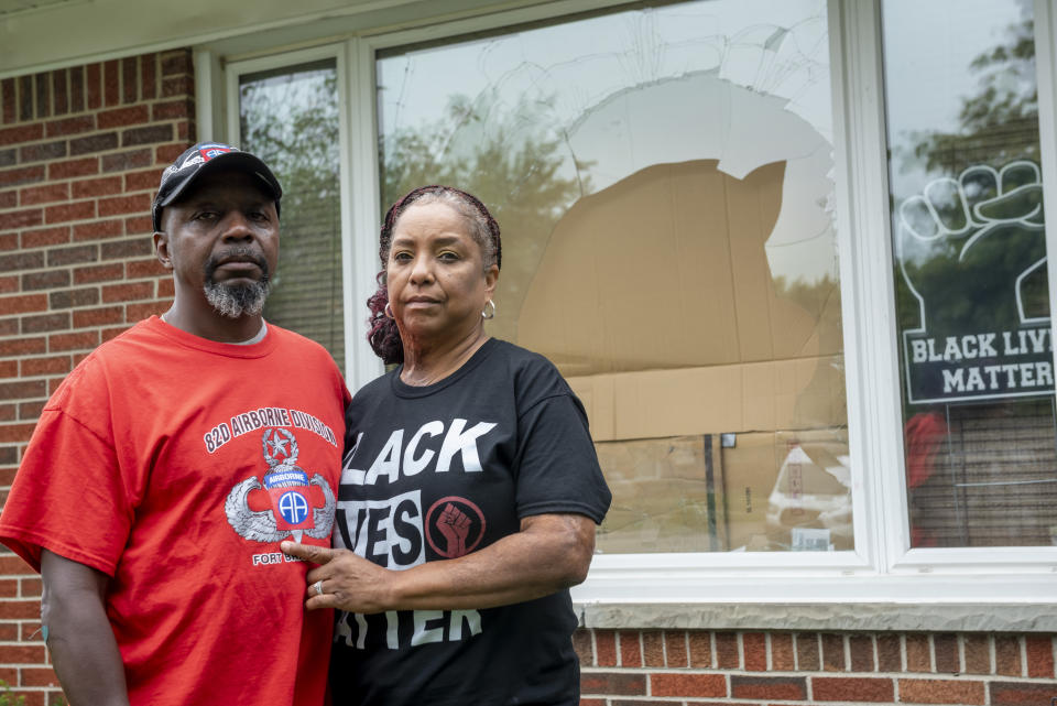 FILE - Eddie Hall Jr. and his wife Candace stand in front of the broken front window of their Warren, Mich., home, on Thursday, Sept. 10, 2020. Some experts say political and social unrest as well as the coronavirus pandemic has taken a disproportionate physical and financial tolls on Black people, resulting in increased anxiety levels among African Americans. (David Guralnick/Detroit News via AP, File)